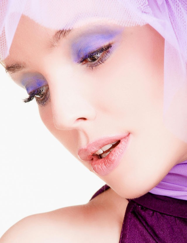 Esta imagen tiene una estética etérea y sofisticada, con tonos rosados que refuerzan la feminidad y la delicadeza. La combinación del maquillaje intenso en los ojos y la textura de humo en el fondo la hace ideal para representar una campaña de cosmética de alta gama, resaltando el concepto de belleza moderna y mística.